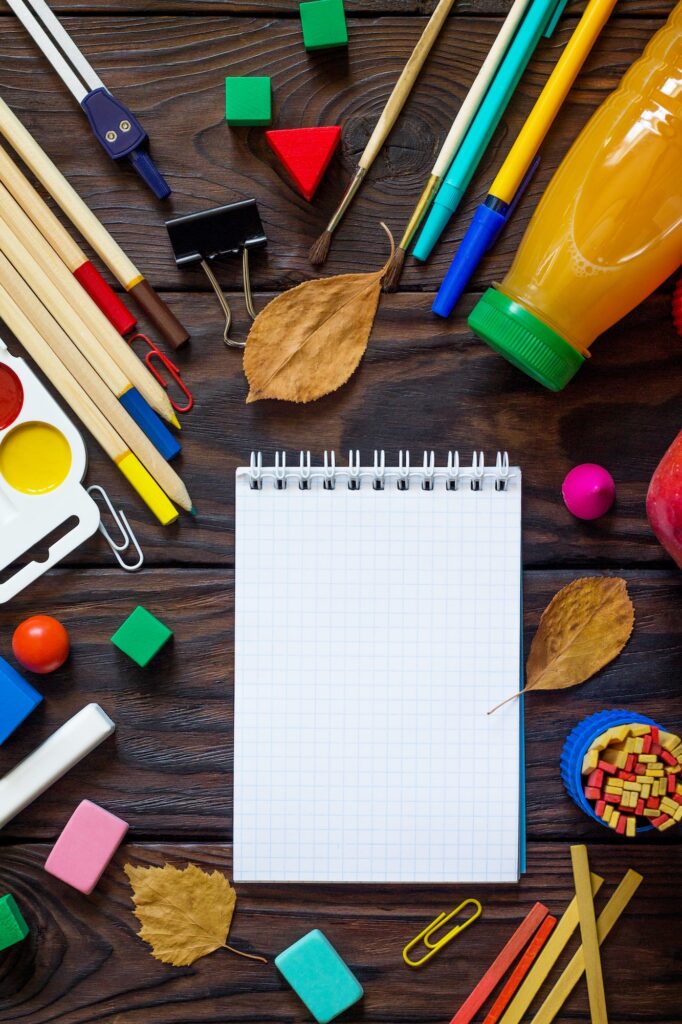 Back to school background with school supplies, autumn leaves and lunch.