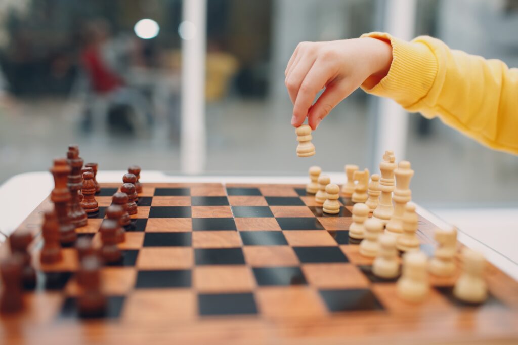 Little kids playing chess at kindergarten or elementary school